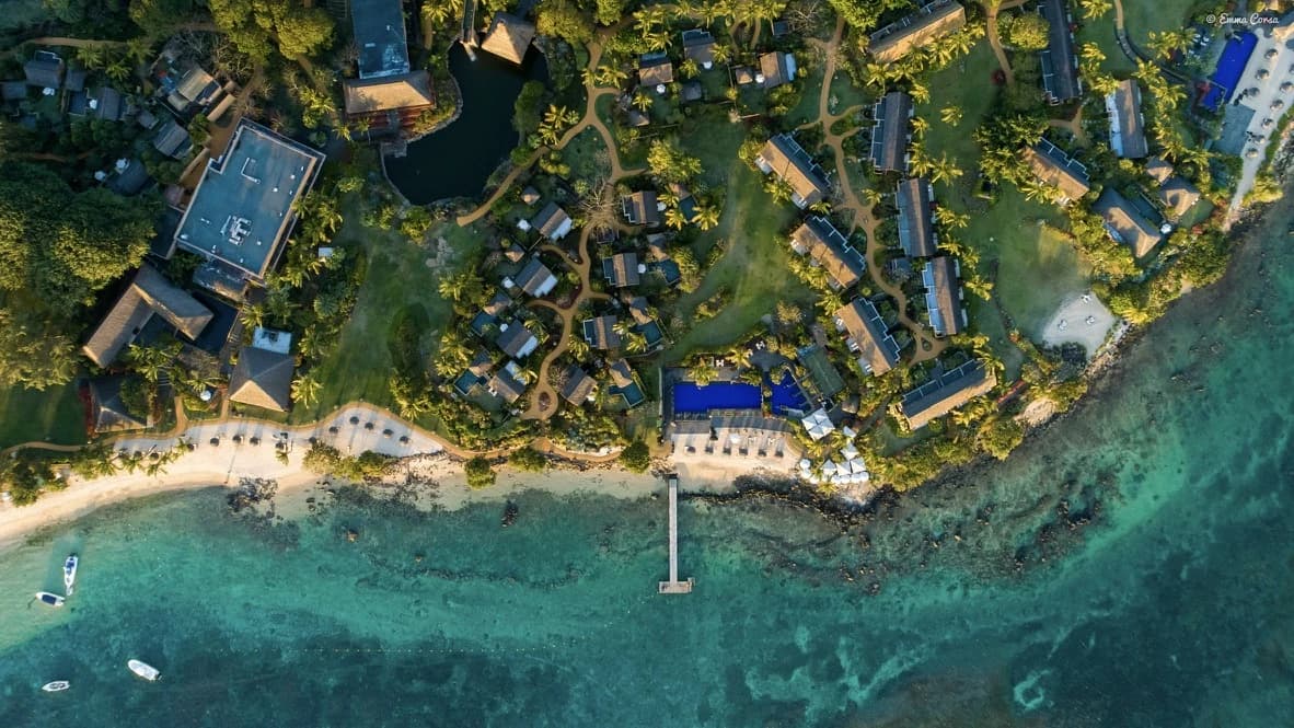 Aerial view of a green coastline and bright blue water